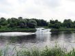 The white boat is floating on the river