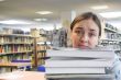female student in a library - too much work