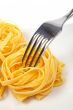 Uncooked pasta nests and fork