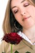 beautiful girl looking at rose - focus on rose