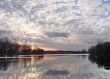 Colorful sunset upon riverside reflected in water