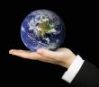 business hand holding earth over black