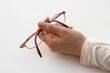 holding pair of glasses