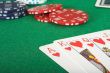 casino tokens and a royal flush over green