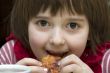 A little girl eats pizza