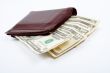 Old leather wallet with bills inside