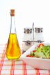 Oil bottle, green salad, salt and pepper