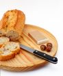 Pate, bread, hazelnuts and knife on wood plate
