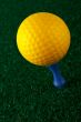 Yellow golfball and blue tee