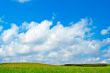 Green field, blue sky and white clouds