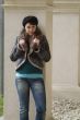 young woman leans at a pillar