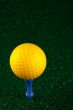 Yellow golfball and blue tee