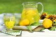 Pitcher of cool lemonade with glass on table