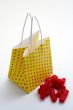 Yellow shopping bag and pieces of red licorices