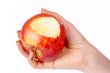 Bitten red apple in hand