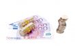 Stack of coins over a euro bills