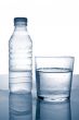 Bottle and glass of mineral water with droplets