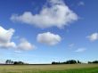 wide shot farmland with blue sky and clouds