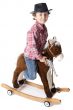adorable boy playing cowboys with a wood horse