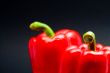 close-up of two red peppers with dark background
