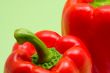 close-up of two red peppers with green background