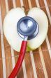 stethoscope and apple with a heart shape