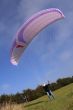 Purple paraglider launching