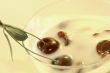 Yoghurt with a cherry on a yellow background
