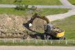 Excavator and man are digging together