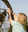 Child playing with bike wheel