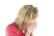 Young blond girl sneezing in the handkerchief