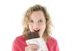 Young blond woman eats chocolate