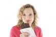 Young blond woman eats chocolate
