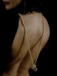 Clous-up of a woman`s back having a low neckline with pearl necklace