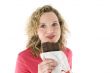 Young blond woman eats chocolate