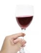 Woman`s hand holding a glass of red wine