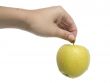 Woman`s hand holding an yellow apple