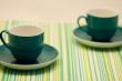 two coffee cups on a placemat
