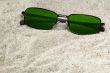 green sunglasses lost in beach sand
