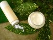 cream, bottle of powder and towel with green leaves