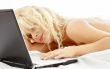 portrait of blond laying in bed with laptop