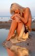 girl sitting on the rock with water reflection