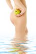 naked woman with green apple in water