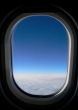 View from aeroplane window onto cloud & blue sky.