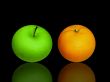 apple and orange on black glass