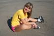 Girl sits on the floor with roller blades