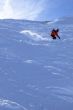 Red skier in powder snow,