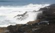 Surf breaking on volcanic rocks
