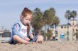 Child playing with sand on a beach