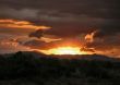 Fiery Sun setting into Rain Clouds